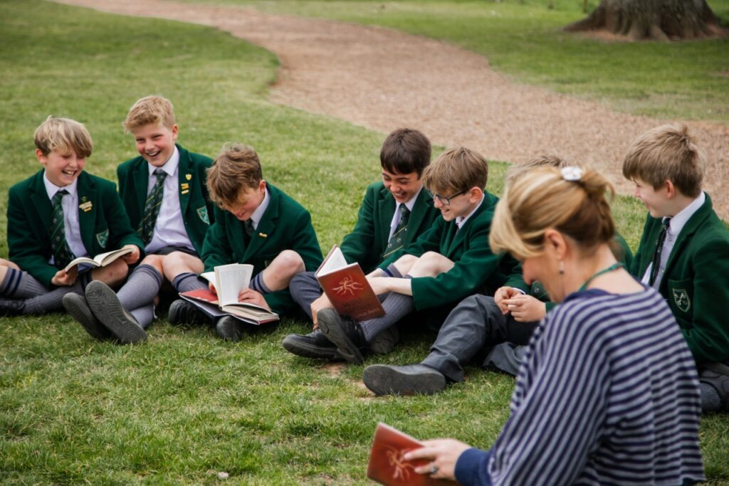 Pupils at St Peter’s Prep in a small class reading outside