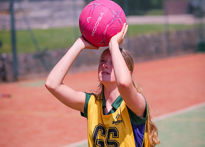 Netball game action shot of a girl about to shoot the ball