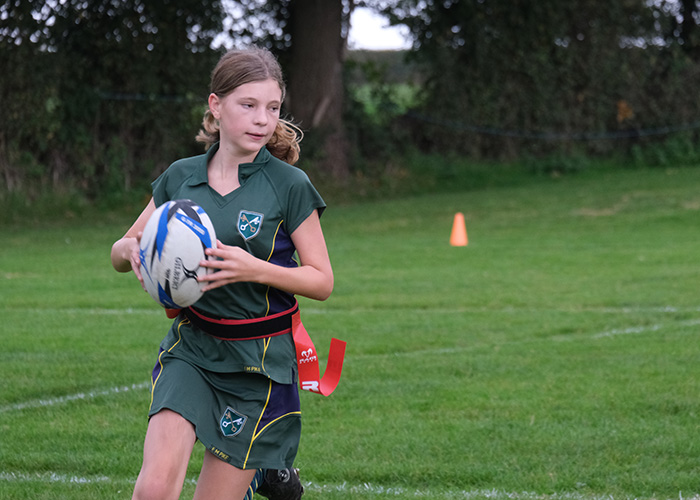 A St Peter's student mid rugby match with a rugby ball