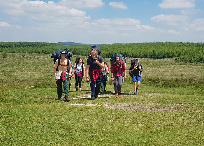 Students with large backpacks enjoying a sunny day for an expedition