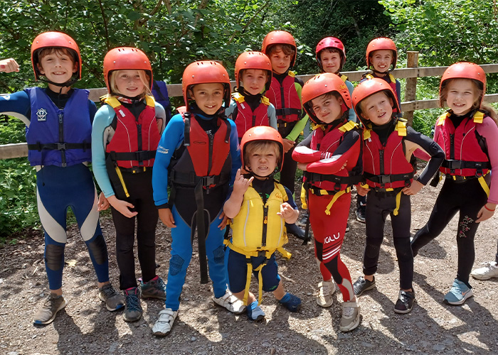Students posing on an outdoor activity in safety gear
