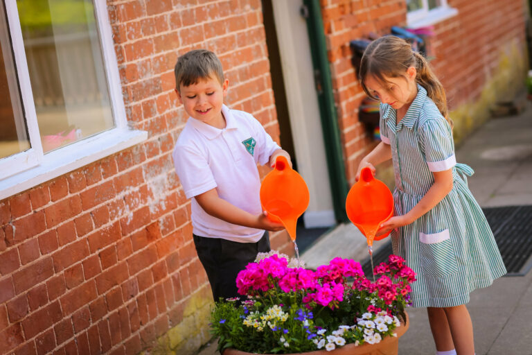 Children watering flowers at St Peter’s Prep