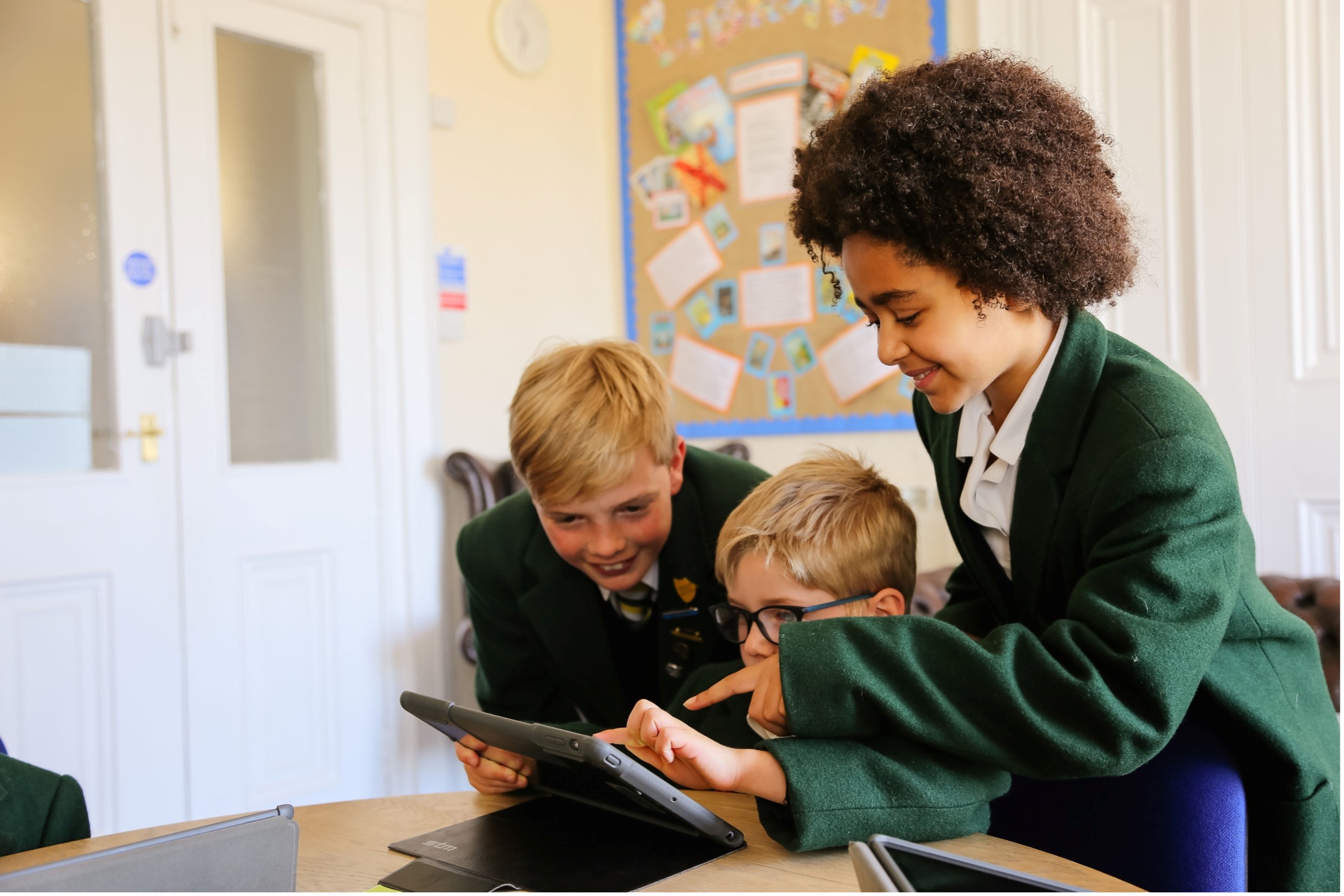 Three children looking at a tablet