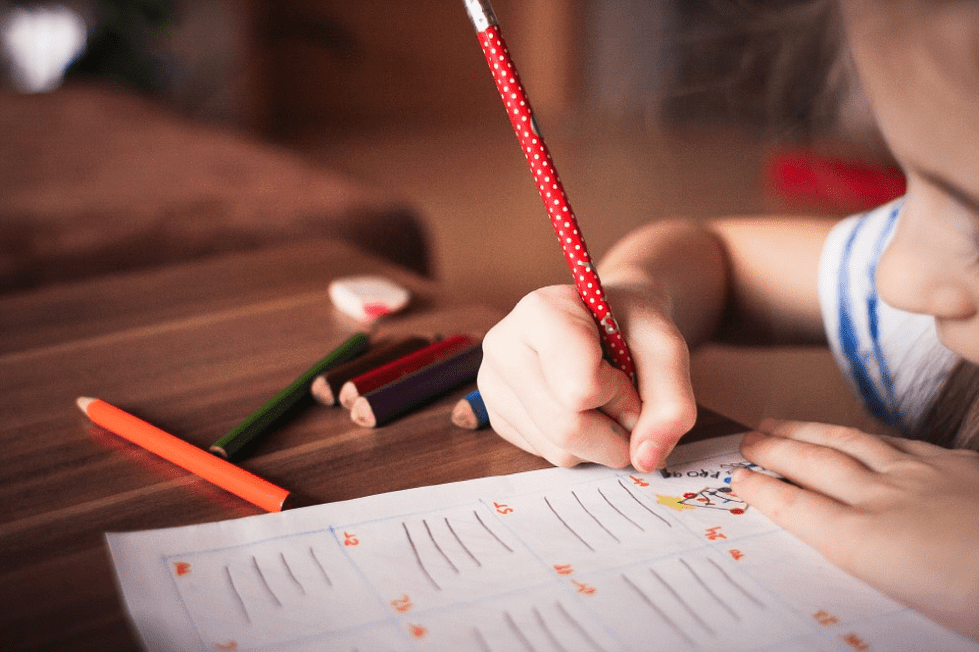 A child writing and colouring at a table