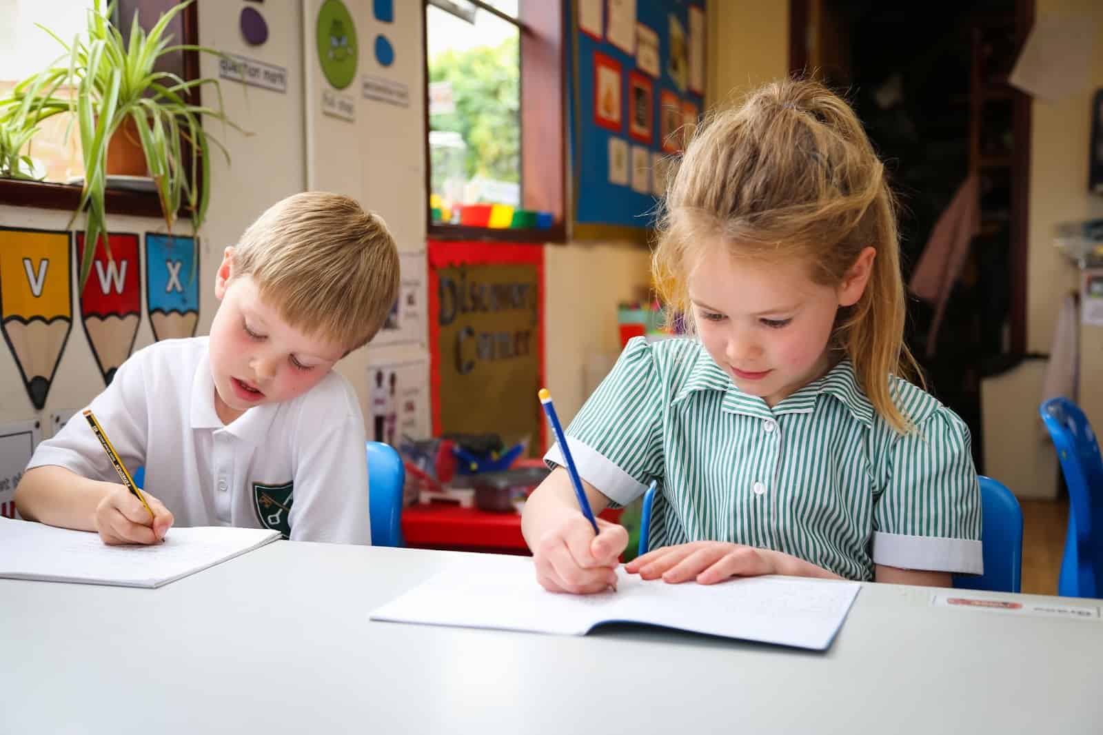 Children writing in classroom