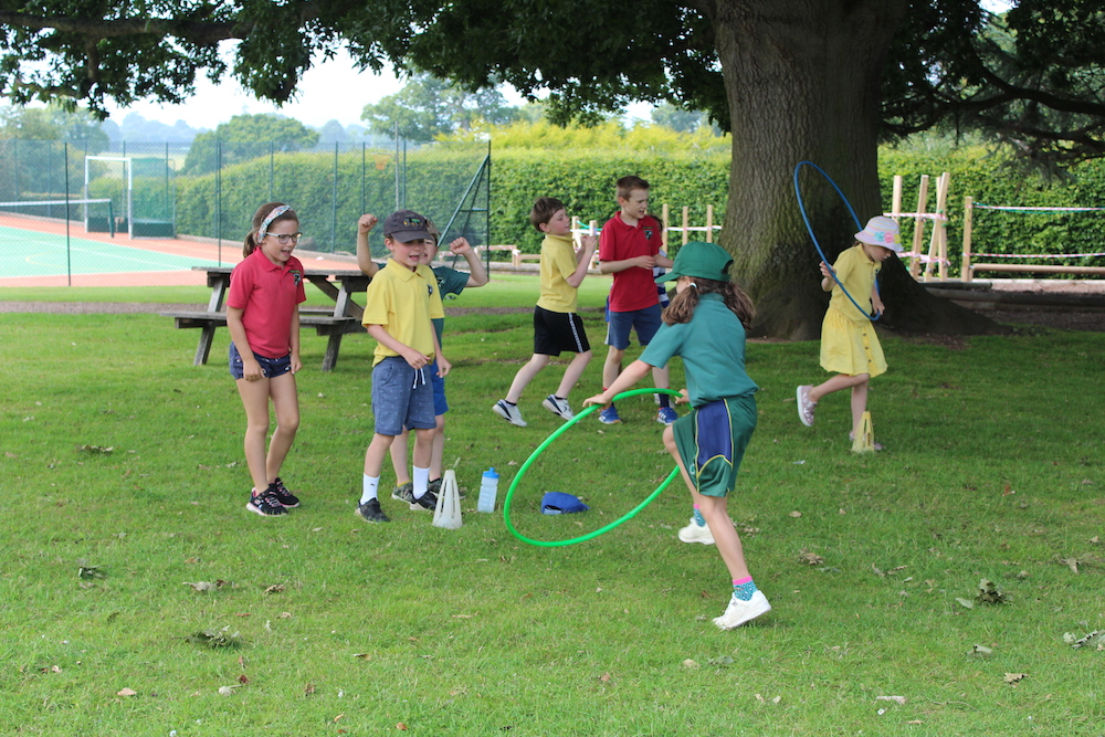 chilren outside playing with a hulahoop