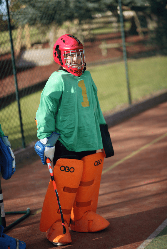 Girl standing in a hockey outfit on the pitch