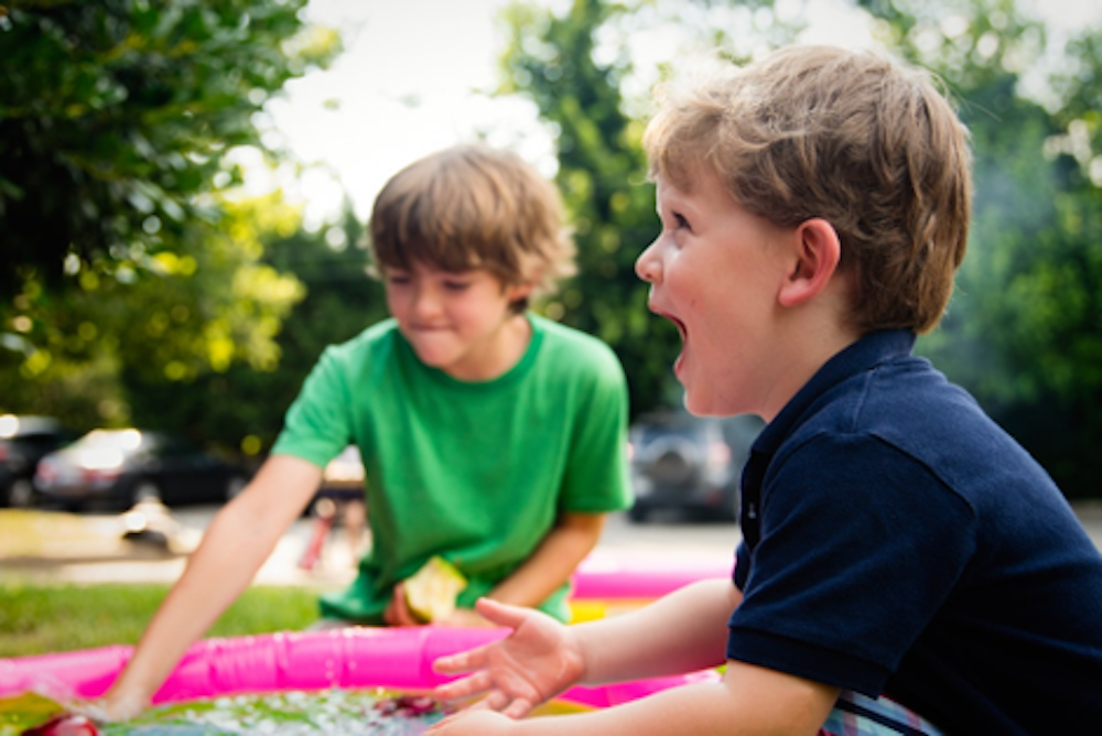 Two young children playing at a family picnic
