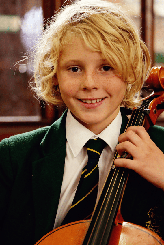 blonde boy holding a chello