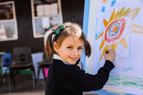A young girl painting a red and yellow flower at St Peter's Prep School