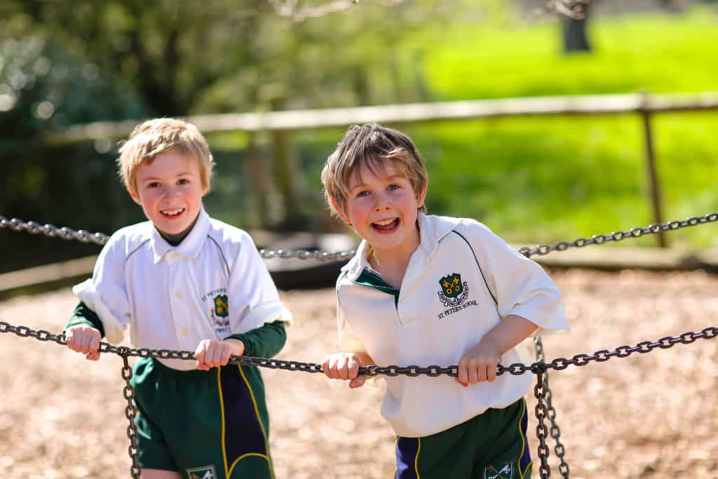 two boys playing in a school park together