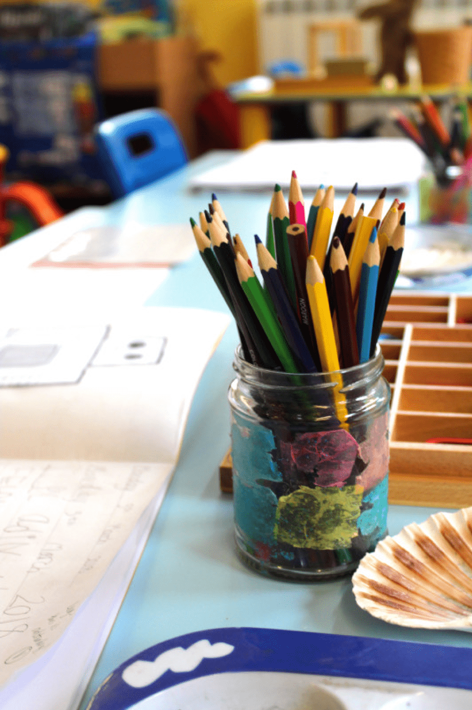 glass pot of colourful pencils on a desk
