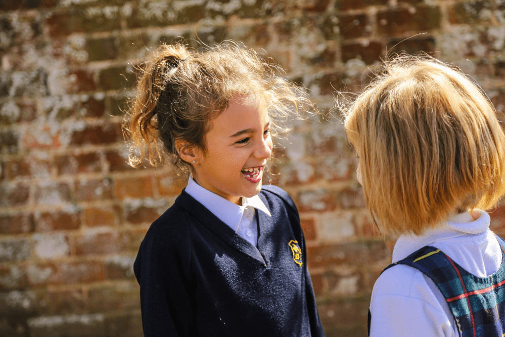 two blonde girls smiling in the sun