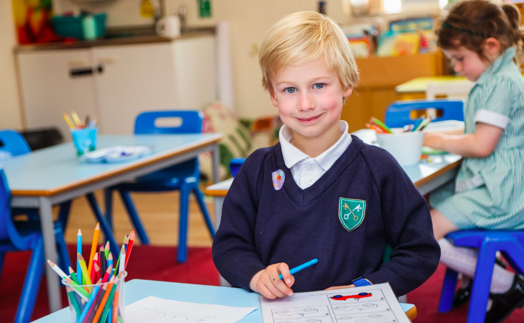 a child colouring in pictures at a school desk