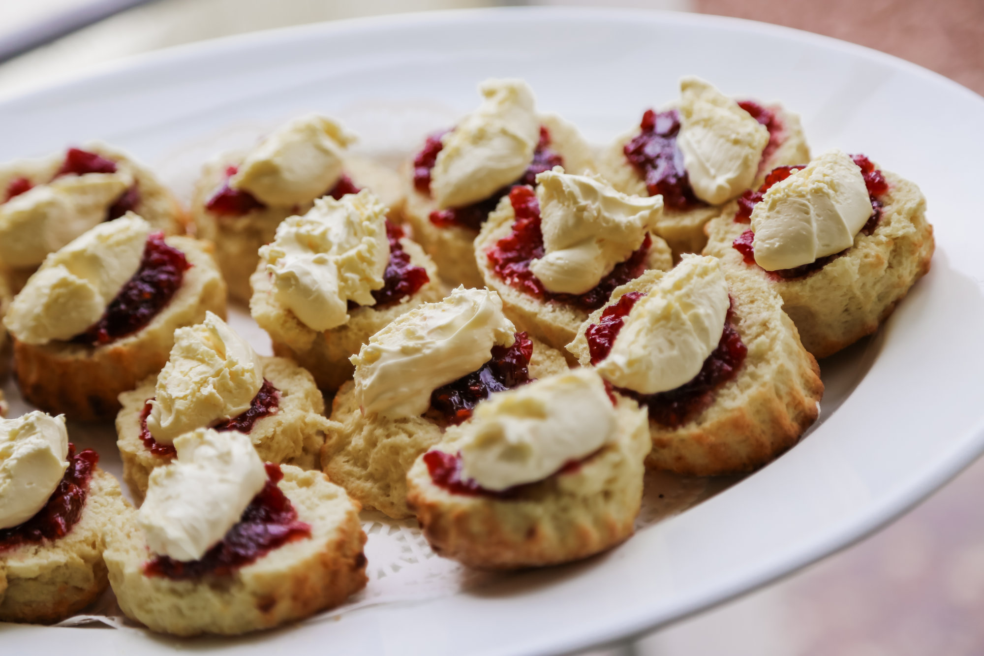 a plate of scones with cream and jam