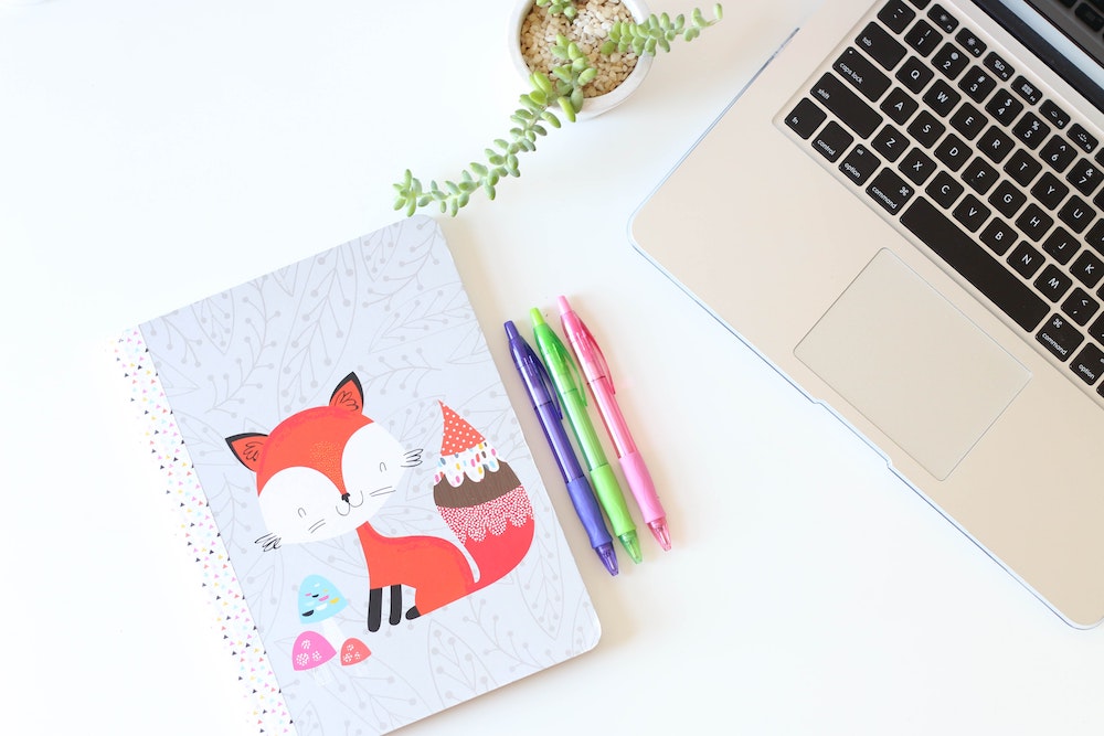 A kid’s notebook and pens