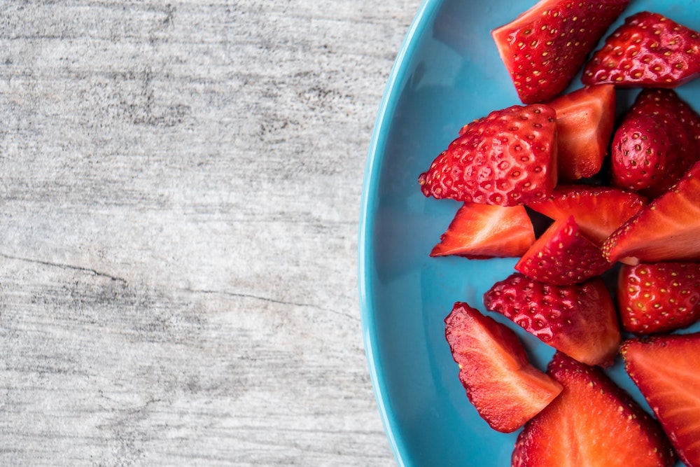 Strawberries sliced in a blue bowl