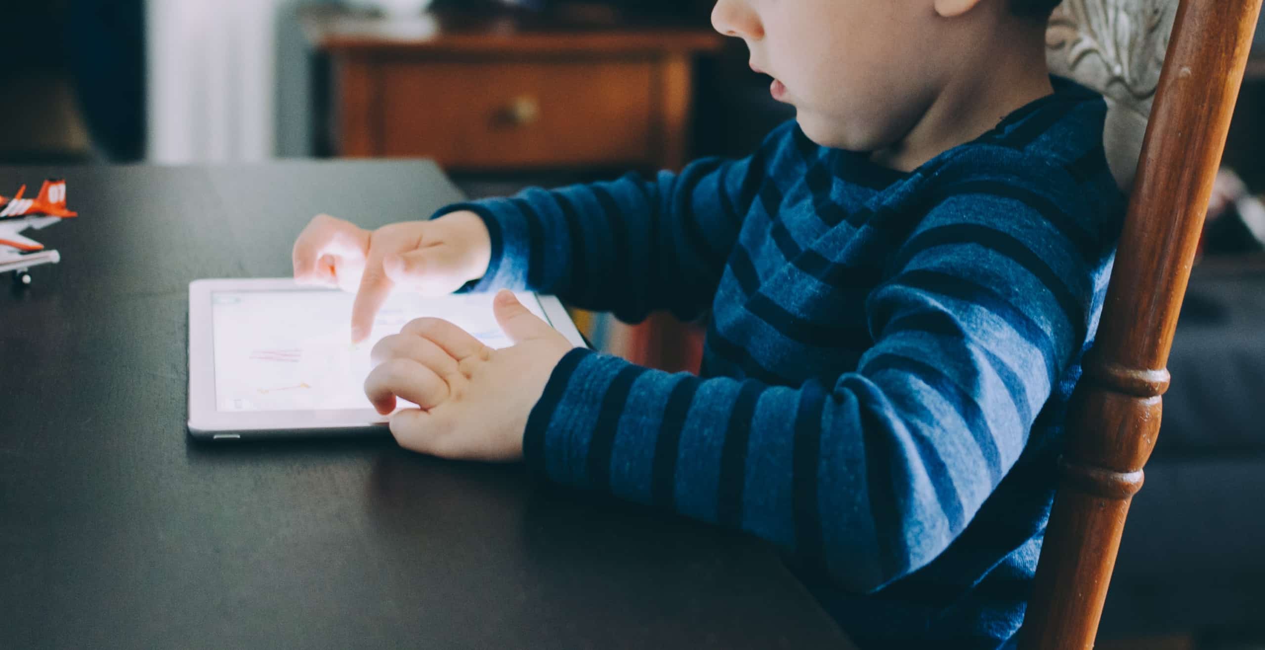 A young boy playing on a tablet