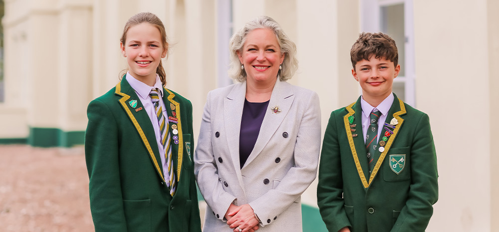 Students outside the school with their head teacher