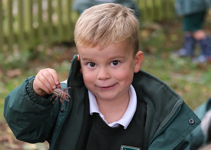 A young student showing a bug toy to the camera