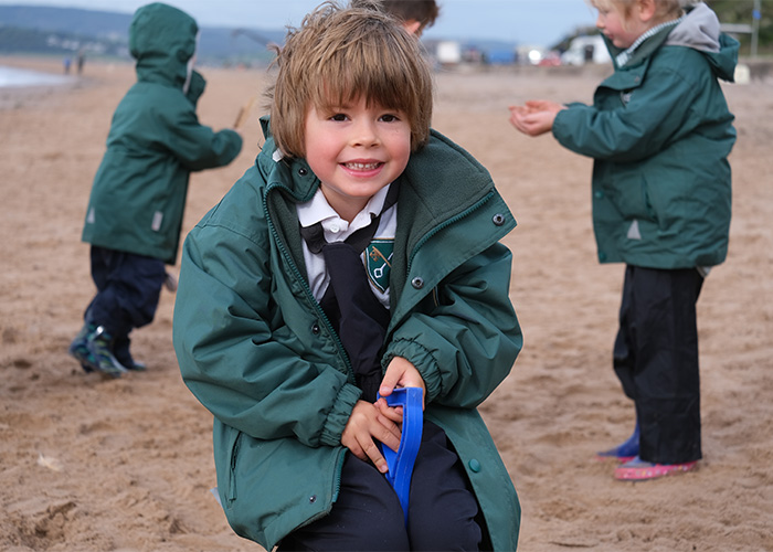 A student outside at the beach with classmates