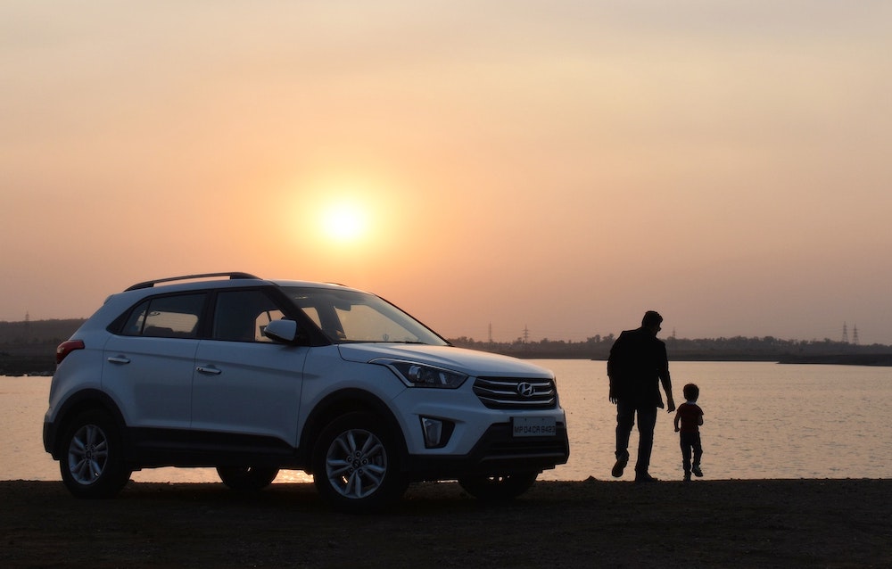 A family standing by a white car