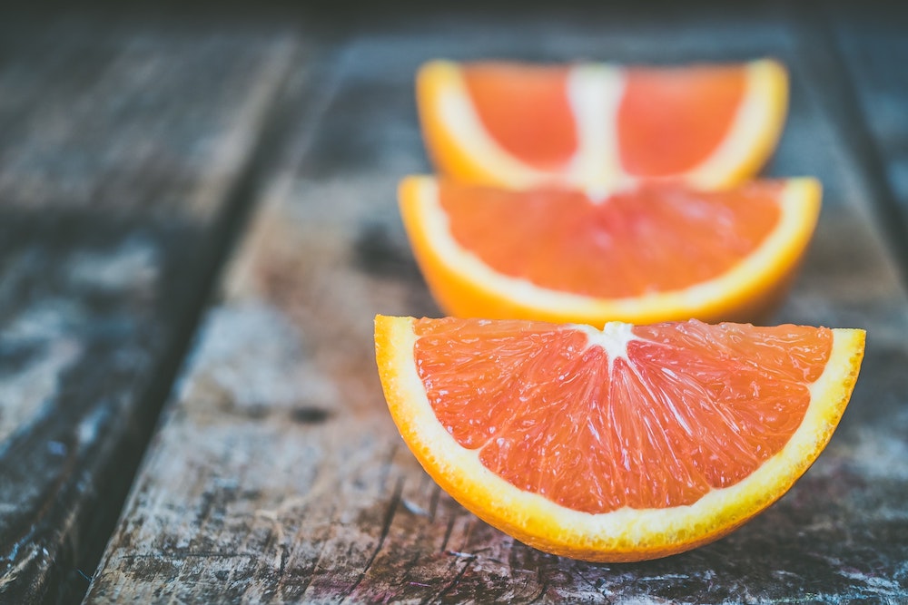 A row of oranges sliced on a wooden table