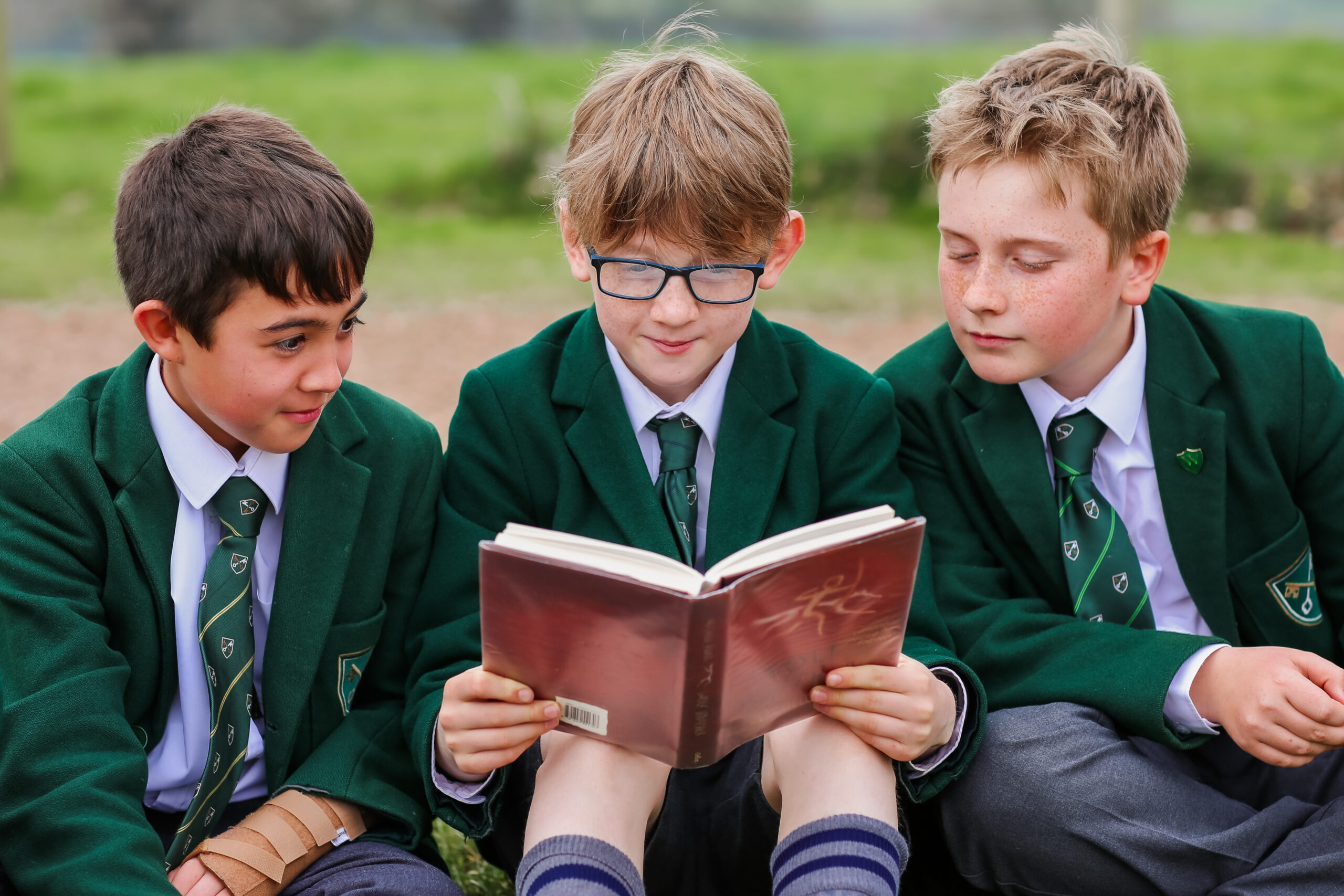 Three students enjoying a book together.